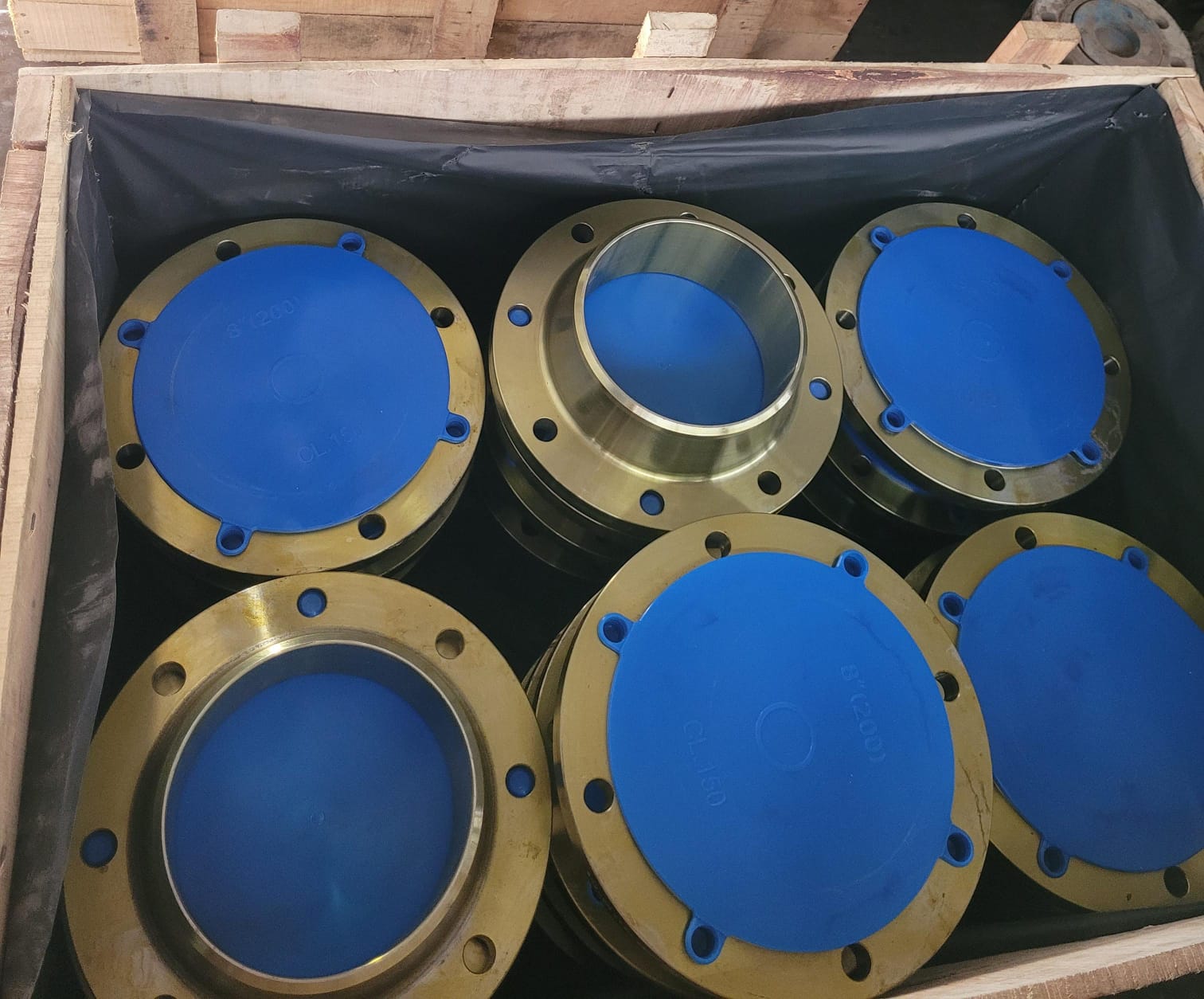 Machined flanges with blue protective covers packed in a timber crate