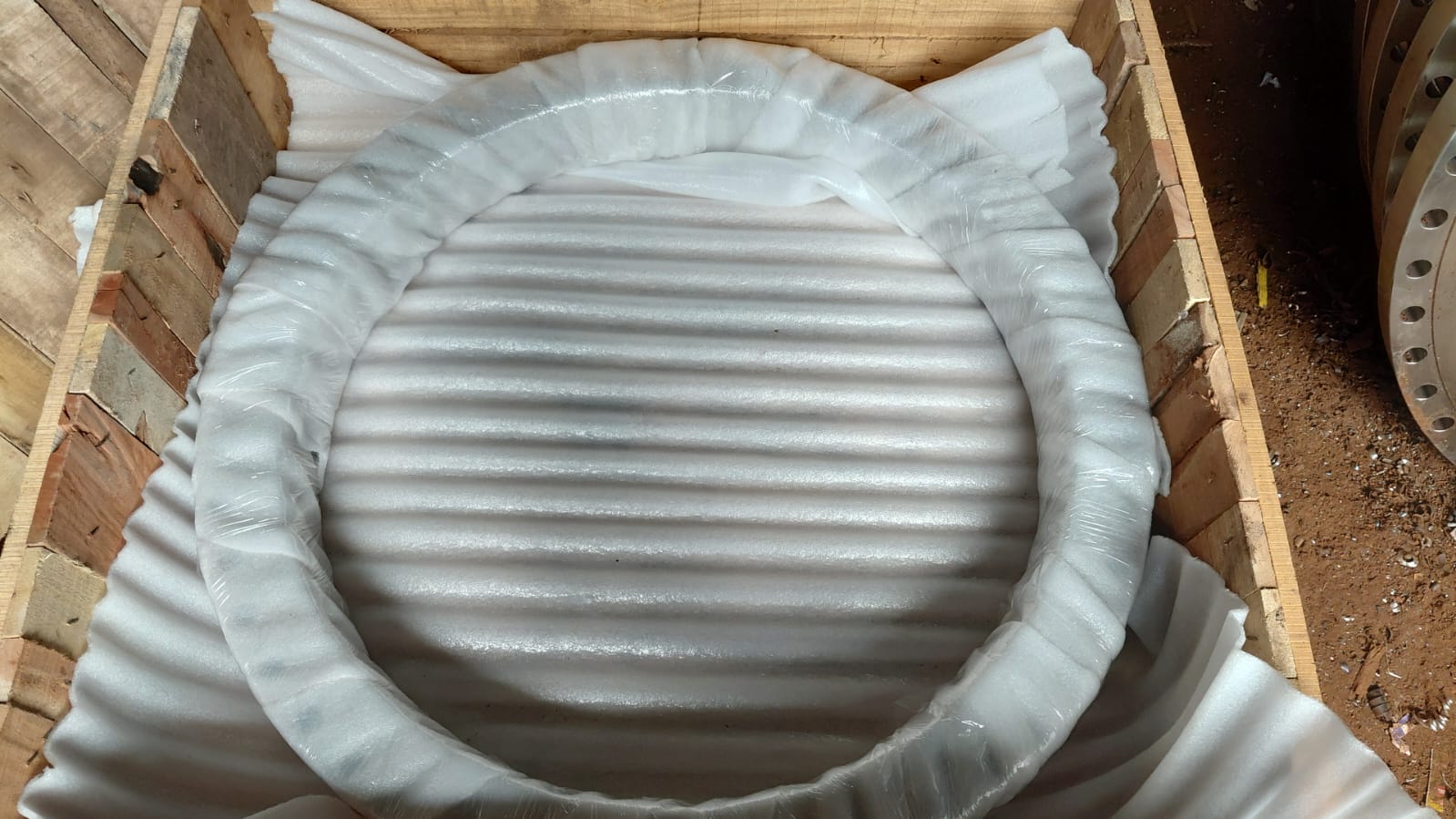 Machined ring component cushioned with foam inside a timber crate